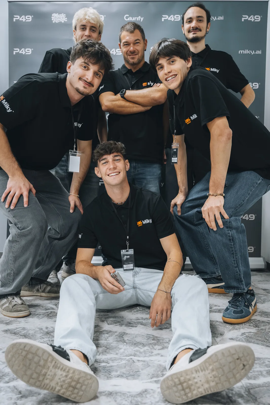 La squadra in maglia nera in posa davanti al pannello con i loghi di P49 e miky.ai.